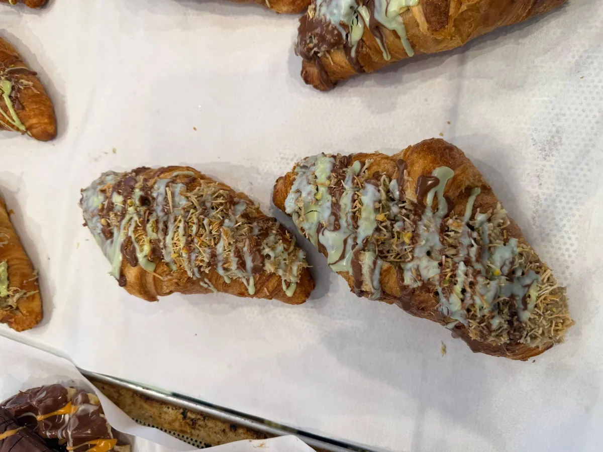 Dubai chocolate croissants topped with kadayif, dark chocolate and pistachio cream