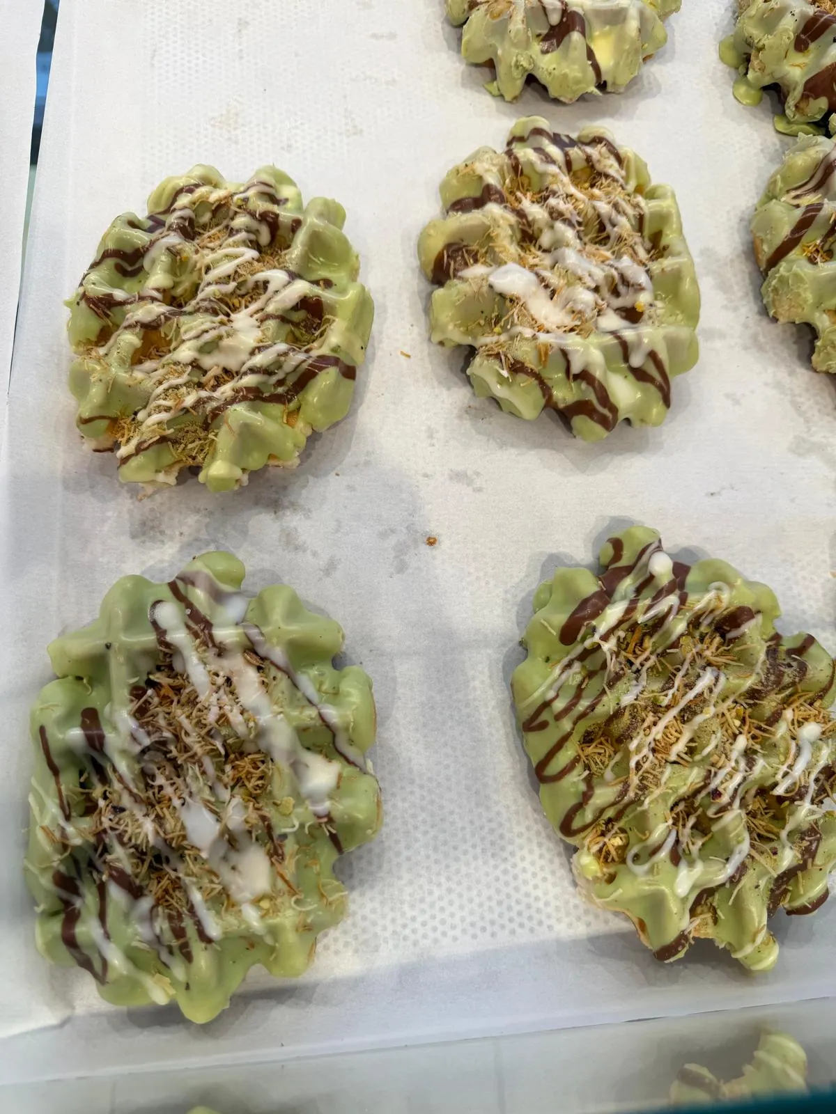 Stroopwafels coated in pistachio chocolate and topped with kadayif