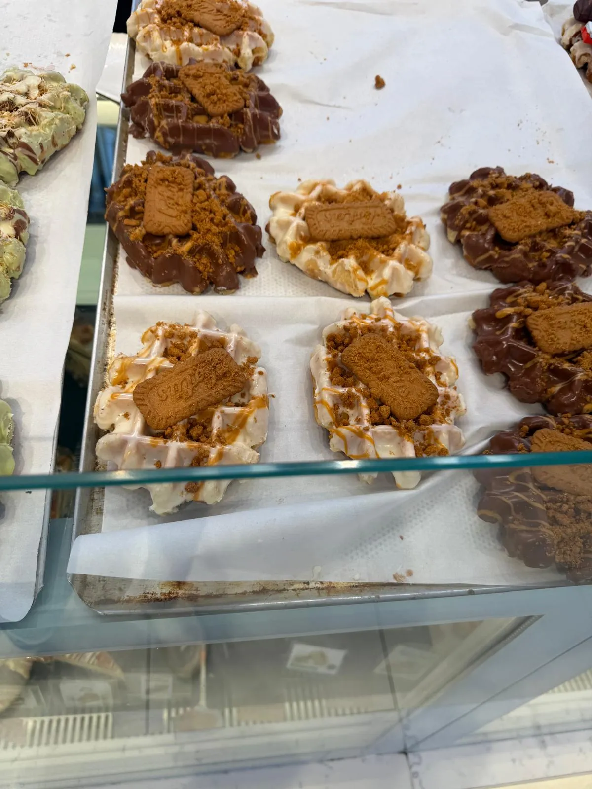 Waffles topped with Lotus biscuit crumb and a line of chocolate