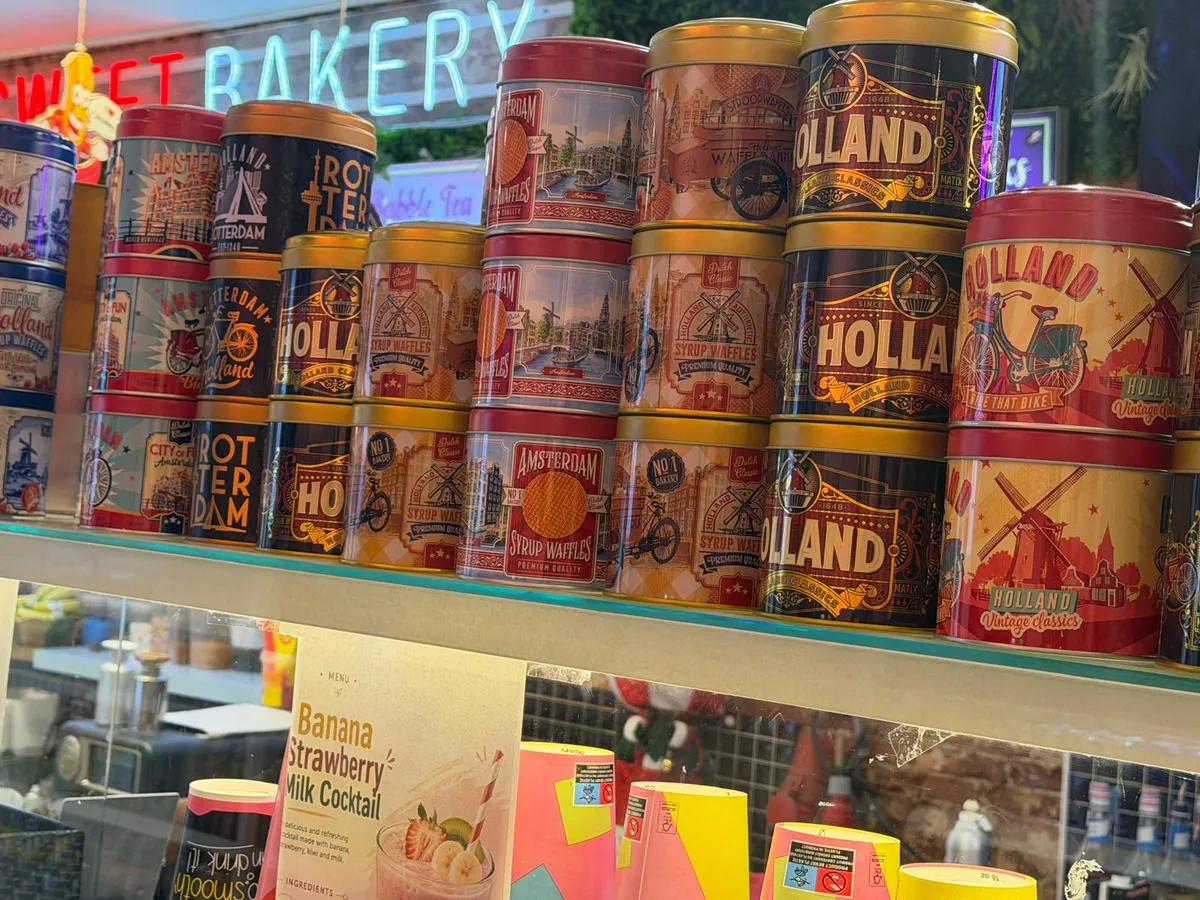 A shelf of Amsterdam and Holland stroopwafel tins above the counter
